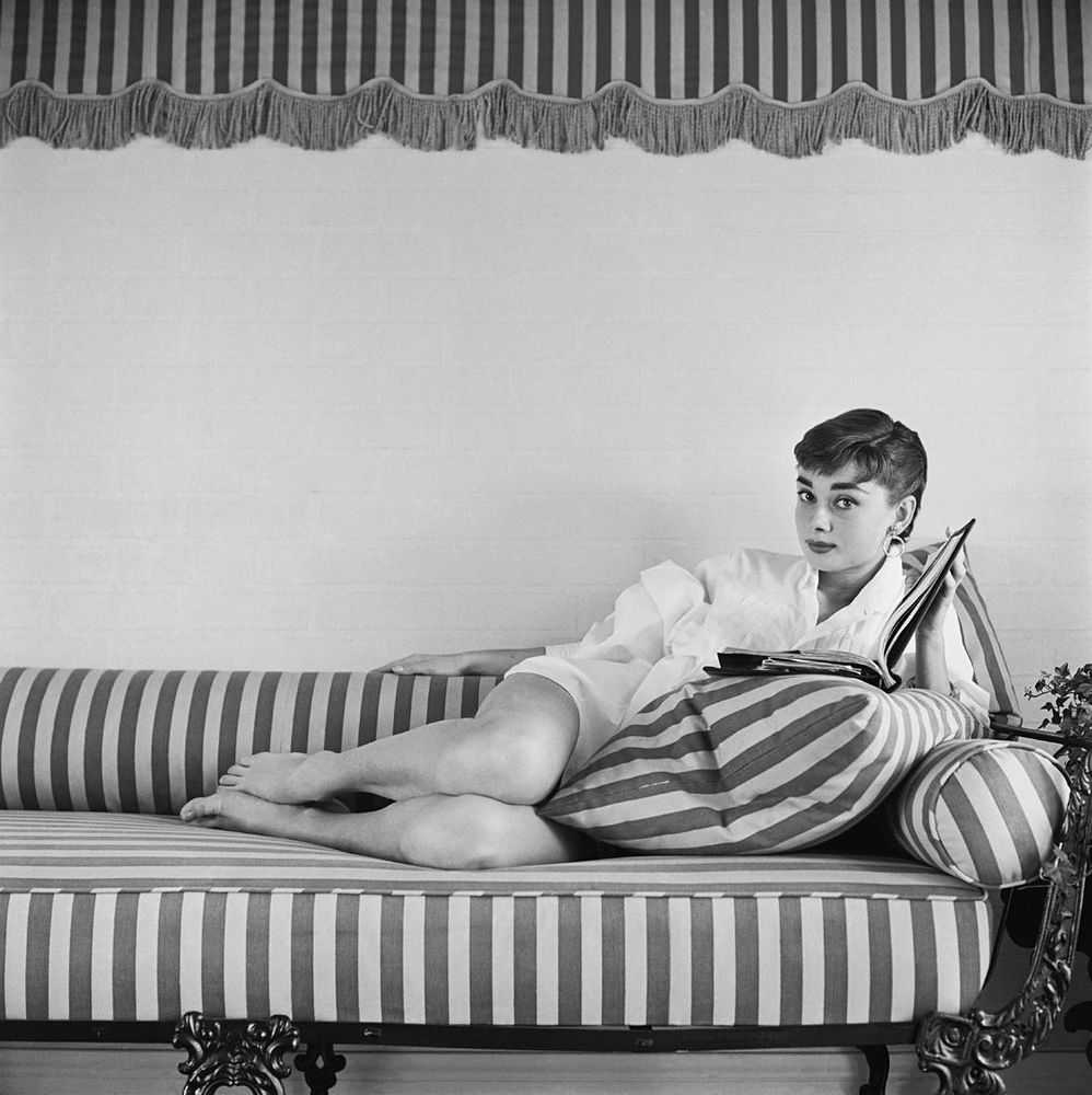 Mark Shaw, ‘Audrey Hepburn on Striped Sofa, Reclines, Book Open, 1954’, 1954, Print, Pigment print on Hahnemϋhle photo rag paper, null,